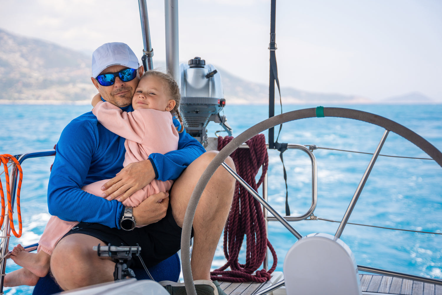 Homme et son enfant sur un voilier après un Accompagnement énergétique complet pour libérer son potentiel et harmoniser chaque aspect de sa vie, comme un voyage guidé avec DHS Stratégie Propulser.